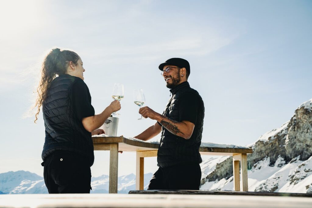 Two people toasting Segnes with a white wine glass.